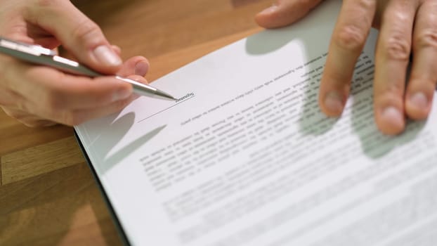 Hands of businessman with pen signing contract document at table closeup. Official certification of important papers concept