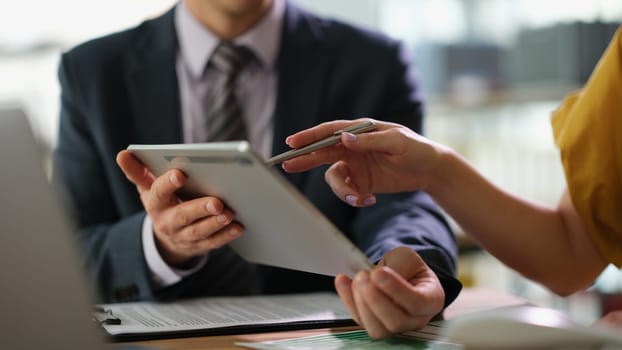 Business partners discussing information on tablet and showing screen with pen closeup. Business strategy marketing concept