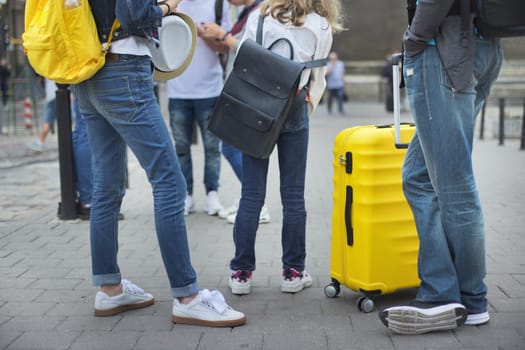 Tourism, travel, journey concept, family father and children, legs and suitcase closeup