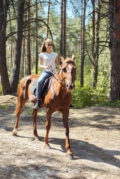 Teenager girl riding a brown horse, horseback riding for people in the park.