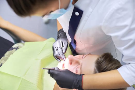 Close up dental treatment procedure in dental office. Dentistry, healthy teeth, medicine and healthcare concept