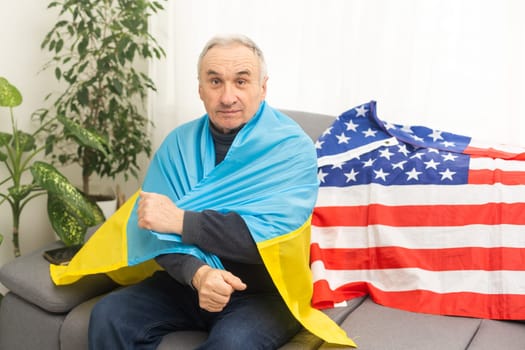 Mature man with flag of Ukraine and usa flag.