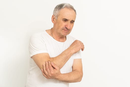 an elderly man hurts his elbow.