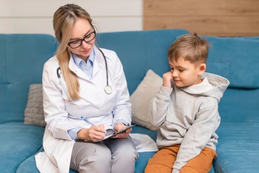 Pediatrician examines a sick child. Sick boy in the clinic. Children's home treatment of the virus.