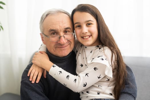 Little granddaughter hugging her grandfather.