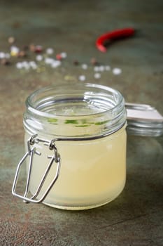 Close up meat broth in an open glass jar. Selective focus. Vertical orientation.
