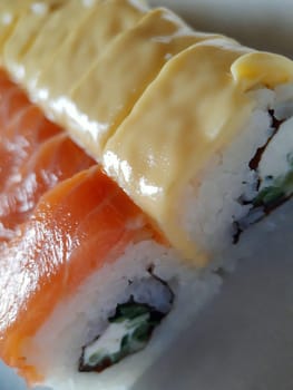 Appetizing sushi with fish and cheese close up.