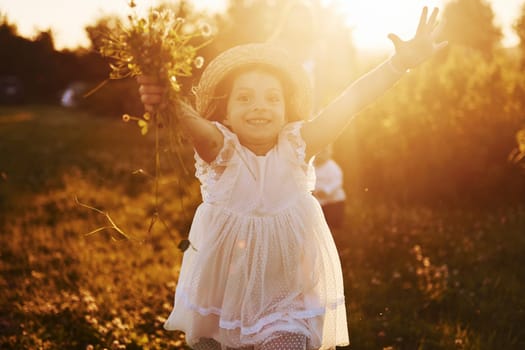 Beautiful lightbeam. Mother with boy and girl spending free time on the field at sunny day time of summer.