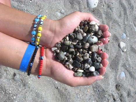 sea pebbles in his hands in the form of heart