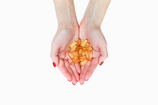 Scattering of transparent yellow pills. Handful of capsules in palm of hand, close-up, isolated on white background. Capsules fish oil, omega 3. Healthy lifestyle, dietary nutritional supplements.