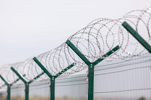 Fencing of sensitive sites with barbed wire. Barbed wire. Restriction of freedom. Prison fence. Forbidden territory. The concept of security. The concept of the ban