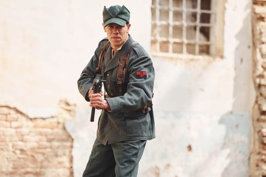 TERNOPIL, UKRAINE - June 2020 UPA Ukrainian Insurgent Army movie filming. Pictures of backstage. Young soldier with weapon near old building.