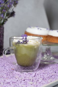 matcha green tea with mousse cakes on a table decorated with lavender flowers, spring still life. High quality photo