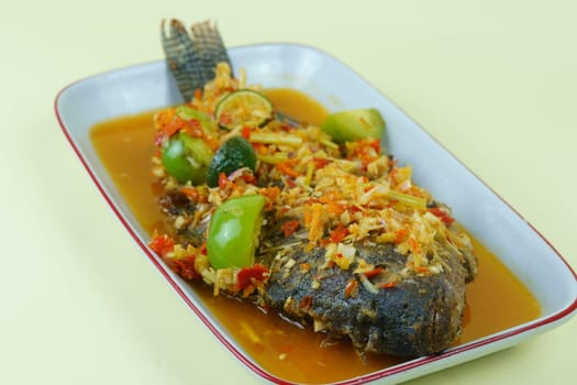 Pecak Ikan Mujair Betawi is a traditional Indonesian dish that originated from Betawi, the native people of Jakarta, Indonesia. Isolated and copy space.