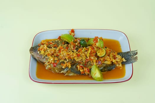 Pecak Ikan Mujair Betawi is a traditional Indonesian dish that originated from Betawi, the native people of Jakarta, Indonesia. Isolated and copy space.