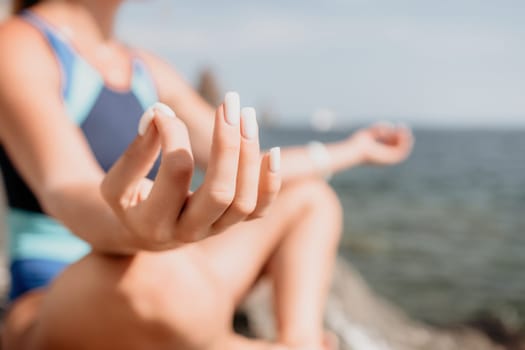 Woman sea yoga. Back view of free calm happy satisfied woman with long hair standing on top rock with yoga position against of sky by the sea. Healthy lifestyle outdoors in nature, fitness concept.