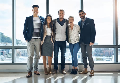 The team youll want to be part of. Portrait of a group of confident young businesspeople standing together in the office at work during the day