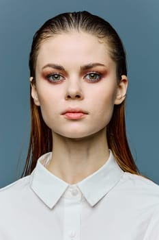 a close vertical portrait of a beautiful woman with her hair laid back, neat evening makeup, standing looking at the camera. Photography from the fashion world. High quality photo