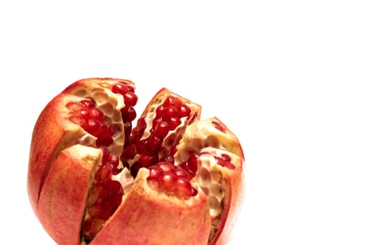 Sliced pomegranate with red grains, isolated on a white background