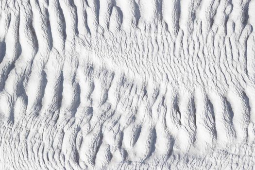 White texture of Pamukkale calcium travertine in Turkey, asymmetric pattern close-up.