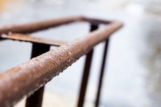 Metal railing with drops of water in the rain close up