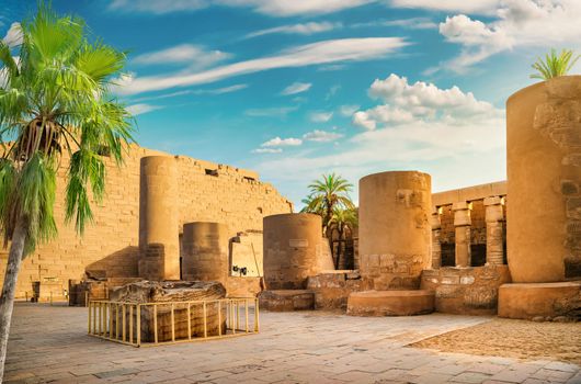 Luxor Karnak temple. The pylon with blue sky and palm