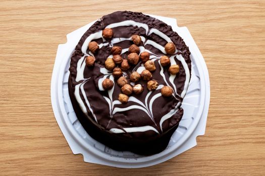 Chocolate cake with nuts on a wooden table close up