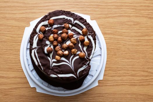 Chocolate cake with nuts on a wooden table close up