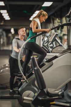 Shot of an attractive young woman exercising on the stepmill machines   at the gym.