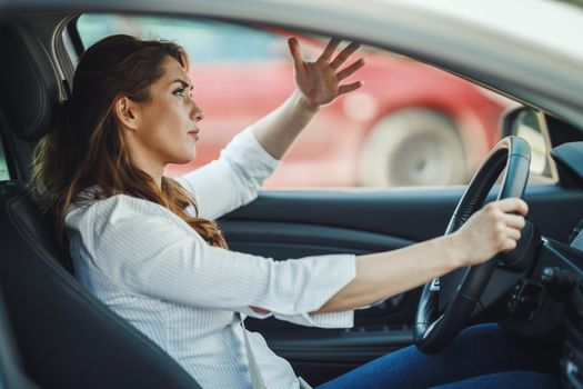 Shot of an stressed businesswoman driving her car in a traffic jam during her morning commute.