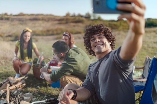 A group of cheerful friends having fun outside their tent at a festival.