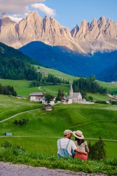 Couple viewing the landscape Italy dolomites Val di Funes in summer, Santa Magdalena village magical Dolomites mountains, Val di Funes valley, Trentino Alto Adige region, South Tyrol, Italy,