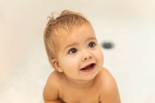 cute blonde baby smiling in the bathroom.