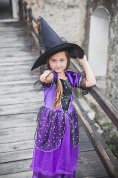 young sorceress on the bridge in the castle conjuring by magic wand.