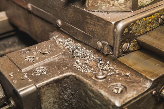 Metal shavings on an old oily machine at the factory.