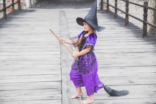 young sorceress is about to take off on a broomstick in the castle.