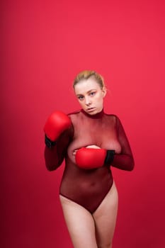 Image of seductive young woman boxer posing isolated on yellow red background in boxing gloves.