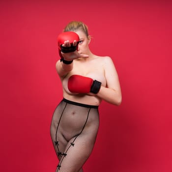 Image of seductive young woman boxer posing isolated on yellow red background in boxing gloves.