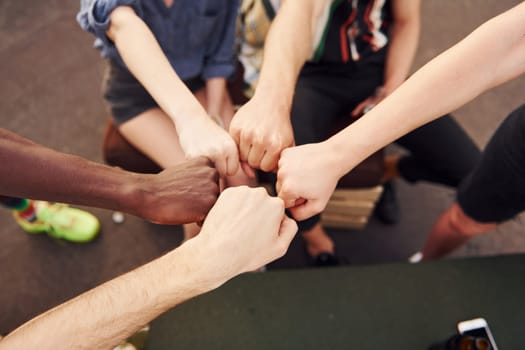 Unity of people. Group of young people in casual clothes have a party at rooftop together at daytime.