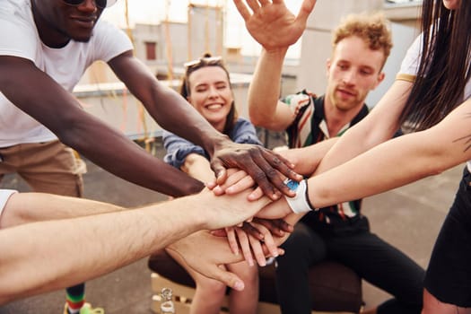 Unity of people. Group of young people in casual clothes have a party at rooftop together at daytime.