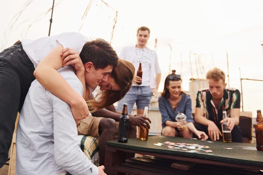 Group of young people in casual clothes have a party at rooftop together at daytime.