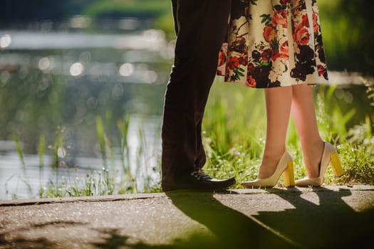 Couple kissing outdoors - Lovers on a romantic date at sunset,girls stands on tiptoe to kiss her man - Close up on shoes.