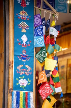 Colorful bhutan bhuddist prayer flags mounted on shop giving common visual across hill stations in India and a common tourist purchase