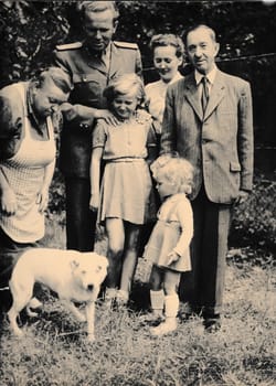 THE CZECHOSLOVAK SOCIALIST REPUBLIC - CIRCA 1960s: Retro photo shows family and dog outside. Black and white vintage photography