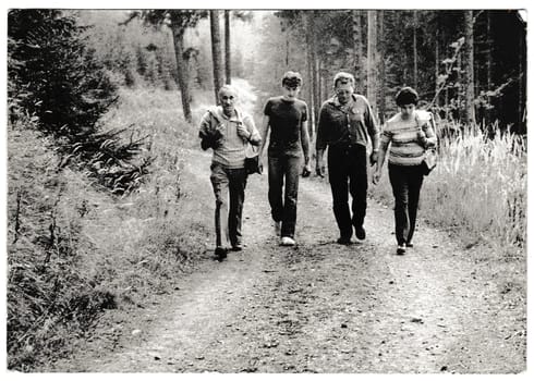 THE CZECHOSLOVAK SOCIALIST REPUBLIC - CIRCA 1960s: Retro photo shows tourists go for a walk in the forest. Black and white vintage photography