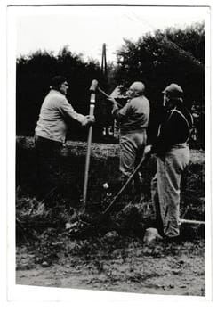 THE CZECHOSLOVAK SOCIALIST REPUBLIC - SEPTEMBER 20, 1988: Retro photo shows volunteers build a touristic sign. Black and white vintage photography