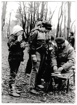 THE CZECHOSLOVAK SOCIALIST REPUBLIC - CIRCA 1980s: Retro photo shows young tourists and their chief in the forest. Black and white vintage photography