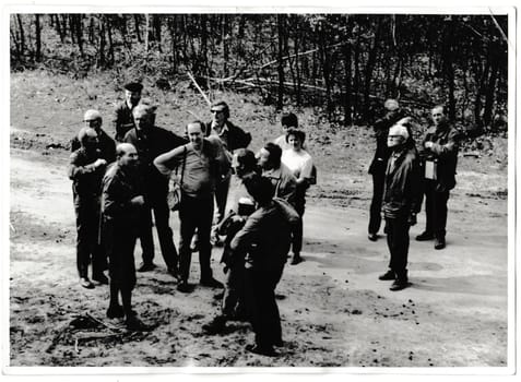 THE CZECHOSLOVAK SOCIALIST REPUBLIC - MARCH 31, 1974: Retro photo shows tourists stand on the path. Black and white vintage photography