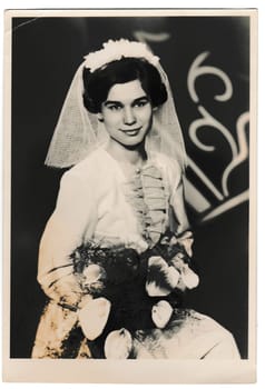 THE CZECHOSLOVAK SOCIALIST REPUBLIC - APRIL 4, 1964: Retro photo shows bride with white kala flowers. Black and white vintage photography.