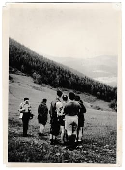 BESKYDY MOUNTAINS, THE CZECHOSLOVAK SOCIALIST REPUBLIC - JUNE 3, 1957: Retro photo shows tourists go for a walk. Black and white vintage photography.